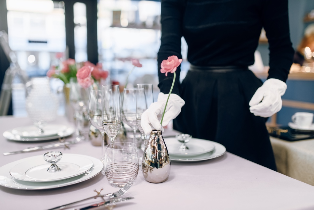 украсена изящно маса с бяла посуда и цветя